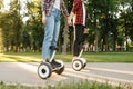 Young couple riding on gyroboard in park at sunset