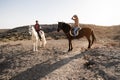 Young couple riding horses doing excursion at countryside during sunset time - Main focus on woman face