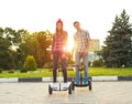 Young couple riding hoverboard - electrical scooter, personal ec