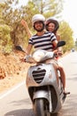 Young Couple Riding Motor Scooter Along Country Road Royalty Free Stock Photo