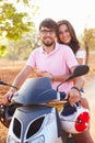 Young Couple Riding Motor Scooter Along Country Road Royalty Free Stock Photo