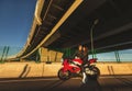 Young couple riding the red sports motorcycle at bridge on sunrise Royalty Free Stock Photo