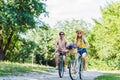 young couple riding retro bicycles in park