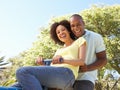 Young Couple Riding On SeeSaw In Park