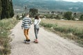 Young couple riding a skateboard on a road. Concept of millenials Skateboarders Royalty Free Stock Photo