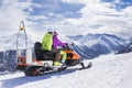 Young couple riding snowmobile snow mountain road