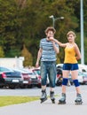 Young couple on roller skates riding outdoors Royalty Free Stock Photo