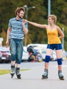 Young couple on roller skates riding outdoors Royalty Free Stock Photo