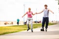 Young couple rollerblading in park holding hands Royalty Free Stock Photo