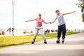 Young couple rollerblading in park holding hands. Royalty Free Stock Photo