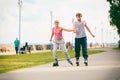 Young couple rollerblading in park holding hands. Royalty Free Stock Photo