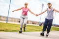 Young couple rollerblading in park holding hands. Royalty Free Stock Photo