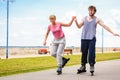 Young couple rollerblading in park holding hands. Royalty Free Stock Photo