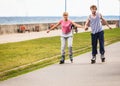 Young couple rollerblading in park holding hands. Royalty Free Stock Photo