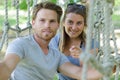 young couple on rope bridge activity course