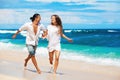 Young couple run by white sand beach along sea surf Royalty Free Stock Photo