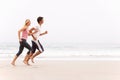 Young Couple Running Along Winter Beach Royalty Free Stock Photo