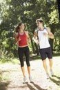 Young Couple Running Along Woodland Path Royalty Free Stock Photo