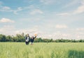 Young Couple running and holding balloon in the green grass below the blue sky look so happy. Royalty Free Stock Photo