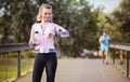 Young couple running in the park at morning. Woman timing her jogging male partner