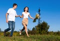 Young couple running on summer meadow Royalty Free Stock Photo