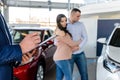 Young couple with salesman near new car signing contract Royalty Free Stock Photo