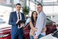 Young couple with salesman near new car signing contract Royalty Free Stock Photo