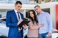 Young couple with salesman near new car signing contract Royalty Free Stock Photo