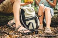 Young couple sat to rest during forest walk along path to fallen tree, people drink water and eat banana fruit. Tourists break for Royalty Free Stock Photo