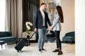 Young couple saying goodbye standing in hotel lobby before man leaving Royalty Free Stock Photo