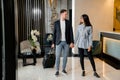 Young couple saying goodbye standing in hotel lobby before man leaving Royalty Free Stock Photo