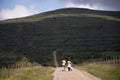 Young couple seen from their back walking with a dog in the countryside. Beautiful light. Soria,