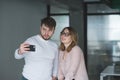 couple selfie office workers do on the background of office. Male Female doing selfie on phone Royalty Free Stock Photo