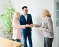 young couple shaking hands deal contract real estate investment business agreement agent handshake signing Royalty Free Stock Photo