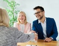 young couple shaking hands deal contract real estate investment business agreement agent handshake signing Royalty Free Stock Photo