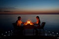 A young couple share a romantic dinner with candles on the beach Royalty Free Stock Photo