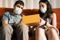 Young couple sharing a gift box with face mask