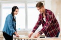Young couple sharing tools while working on improvement of their house Royalty Free Stock Photo