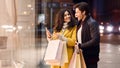 Young couple with shopping bags and smartphone near mall Royalty Free Stock Photo