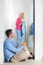 Young Couple Shopping Fitting Room Fashion Shop, Happy Smiling Girl Trying New Clothes, Man Tired Sit On Floor Bored Royalty Free Stock Photo