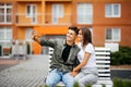 Young couple in shopping. Handsome young couple sitting on the bench and taking a selfie with a mobile phone. Royalty Free Stock Photo