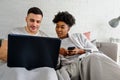 Young couple shopping online in bed with credit card