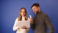 Young couple shopping online. Happy woman searching online shop on a tablet while man is paying with credit card Royalty Free Stock Photo