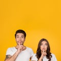 Young couple showing silence gesture putting finger on lips Royalty Free Stock Photo