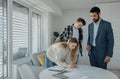 Young couple signing contract when buying their new home and receiving keys from real estate agent. Royalty Free Stock Photo