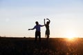 Young couple silhouettes dancing on the field