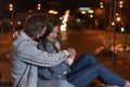 Young couple sits embracing on evening city background Royalty Free Stock Photo