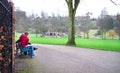 A young couple sits on a park bench in England