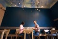 Two people in atmospheric cafe enjoying time spending with each other, having dinner, talking in cafe. Blue background.