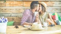 Young couple kissing eachother in a bar and trinking coffe